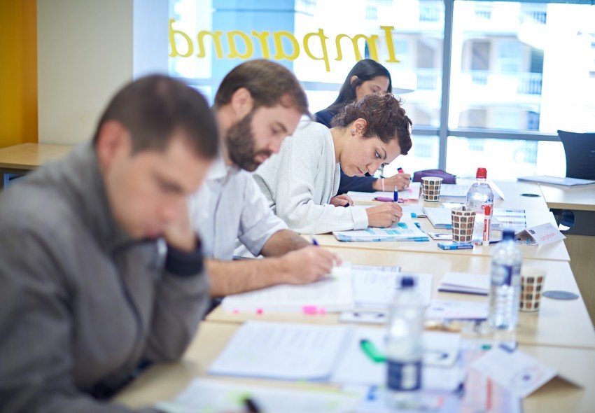 Project management course delegates with their heads down, taking notes